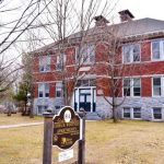 Exterior photo of historic brick schoolhouse now serving as apartments