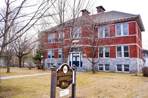 Exterior photo of historic brick schoolhouse now serving as apartments